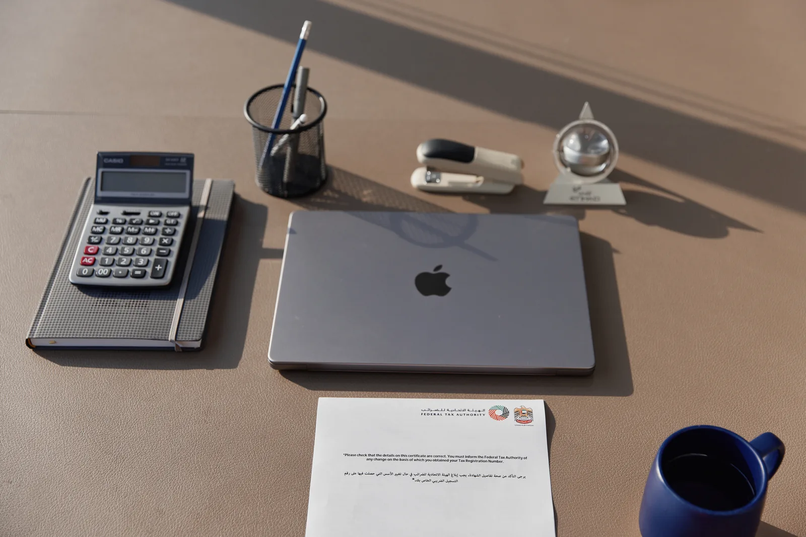 A calm finance desk with a laptop, calculator, and monthly report in daylight